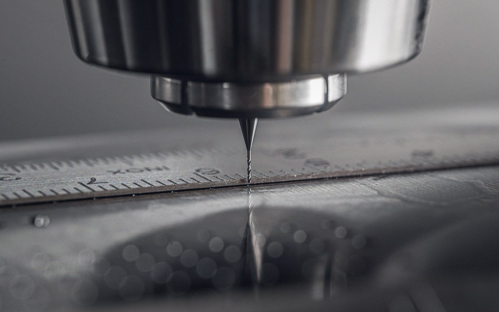 A disc-cutting lathe with a lacquer blank mounted, detail of the cutter head and pitch screw mechanism